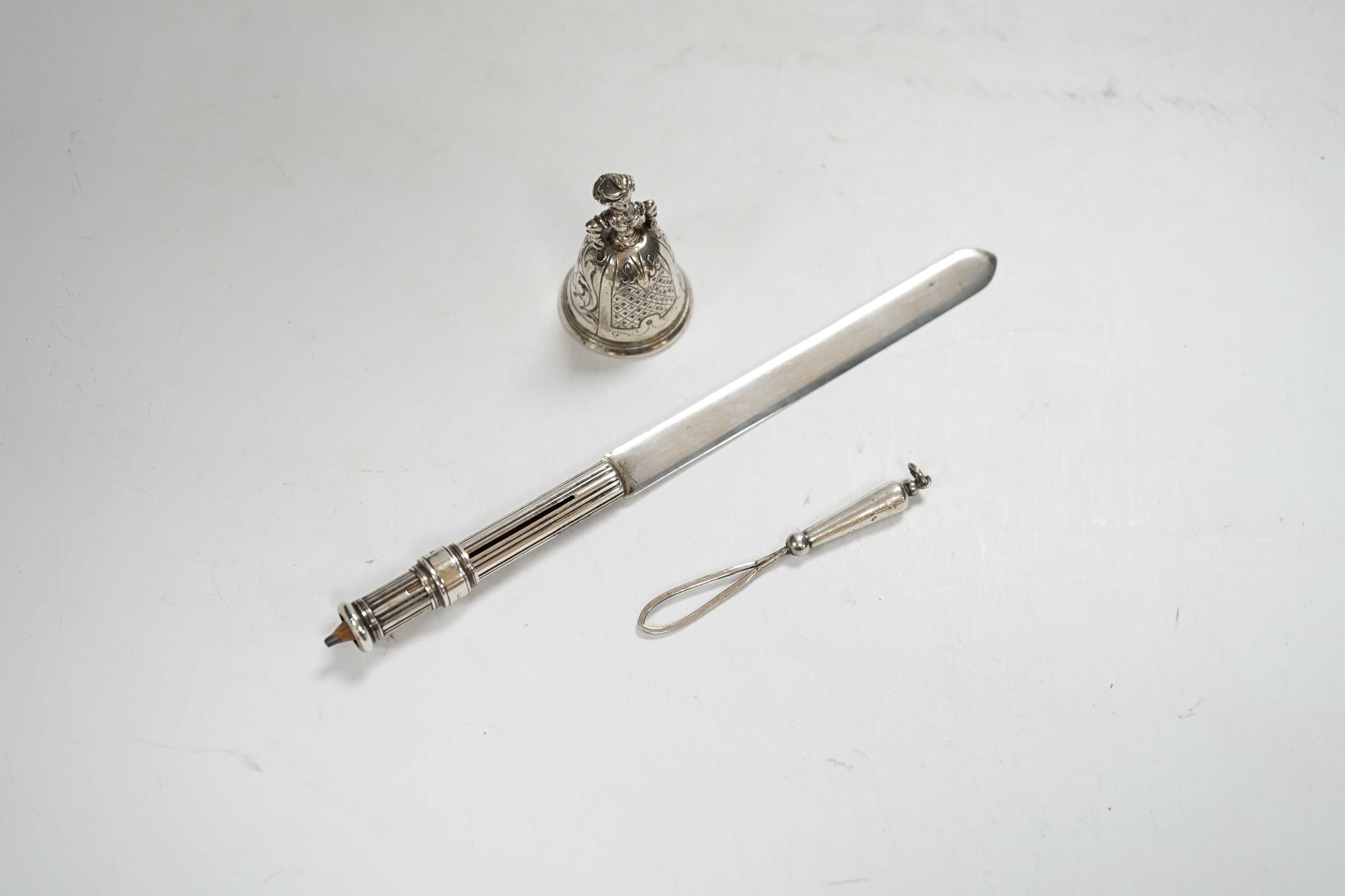 An early 20th century Hanau? miniature figural table bell, 46mm, a late Victorian silver combination paper knife and pencil, Arthur Downing Ltd?, Birmingham, 1897 and a late Victorian silver and Scottish hardstone set ri
